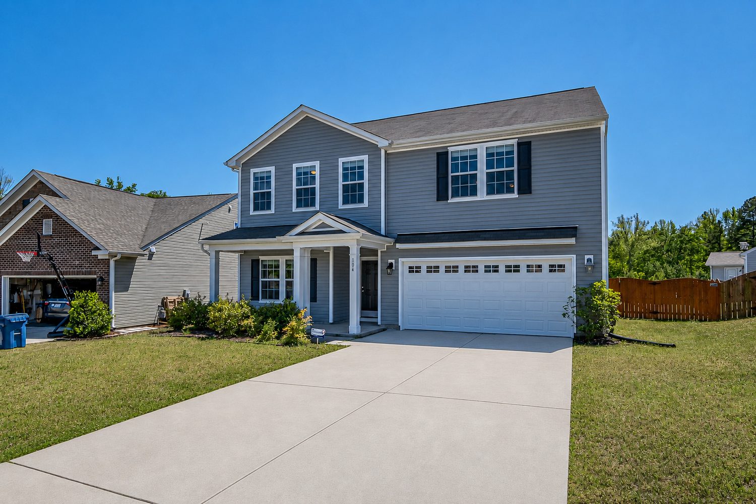 The same property after pressure washing, driveway and siding clean and bright